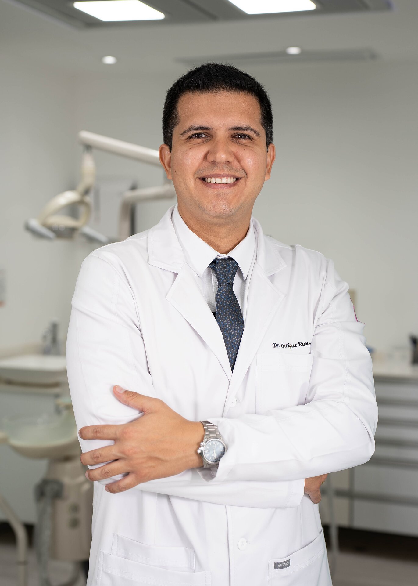 Dr. Enrique Runzer con mandil blanco en su consultorio dental